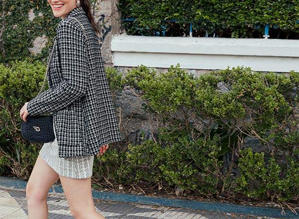 Look de blazer tweed preto com saia branca