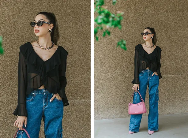 Calça wide leg em jeans azul compondo o look transparente com a blusa de babados